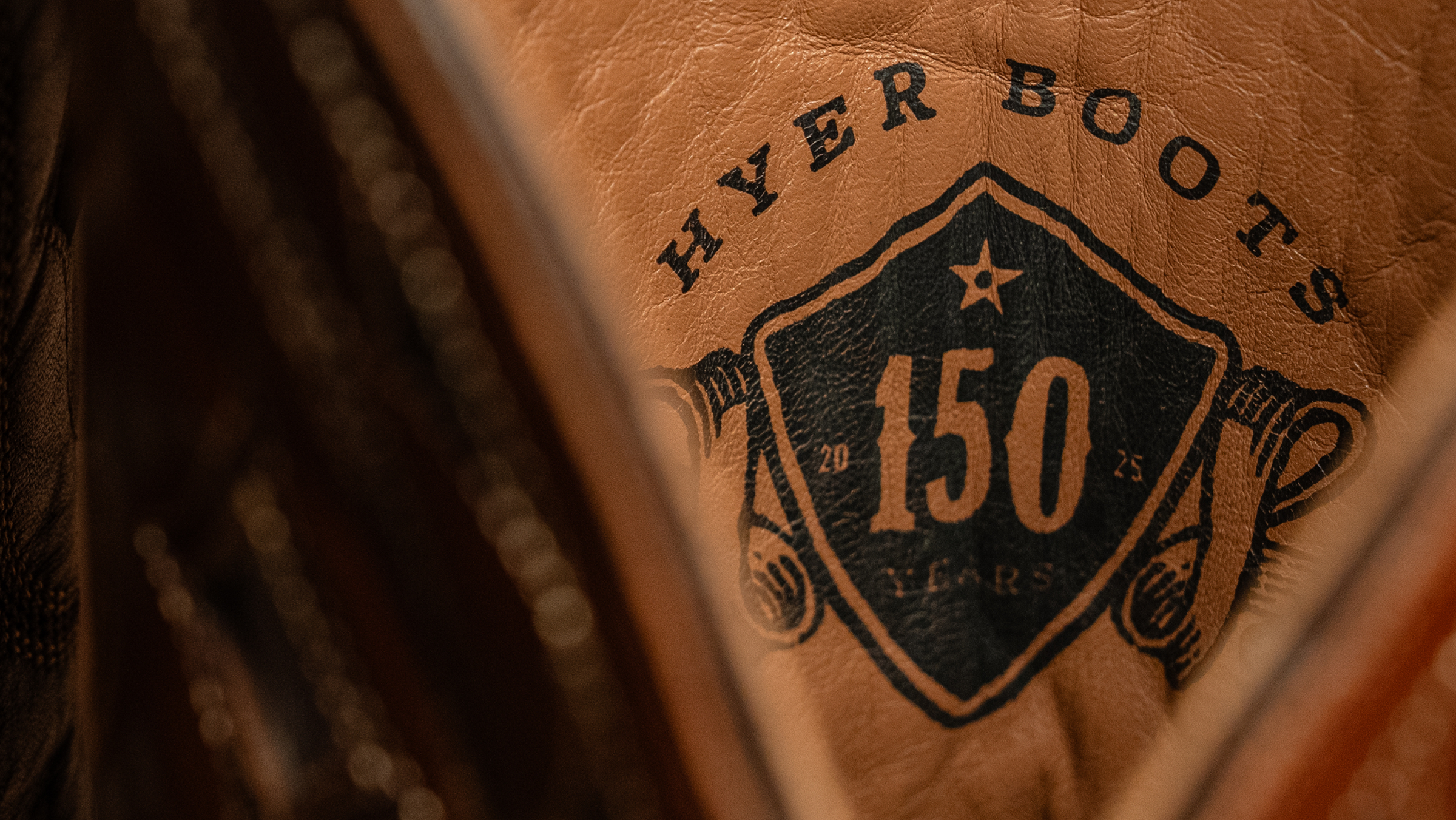 Close-up of a leather boot with 'HYER BOOTS' branding and '150 years' text.