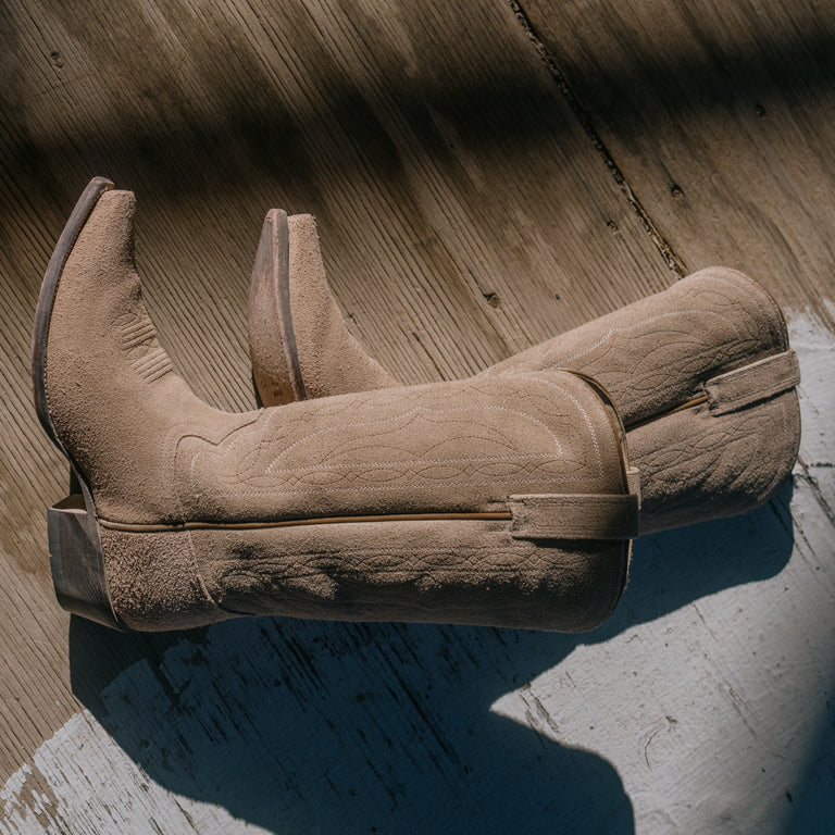 Pair of brown cowboy boots on a wooden floor