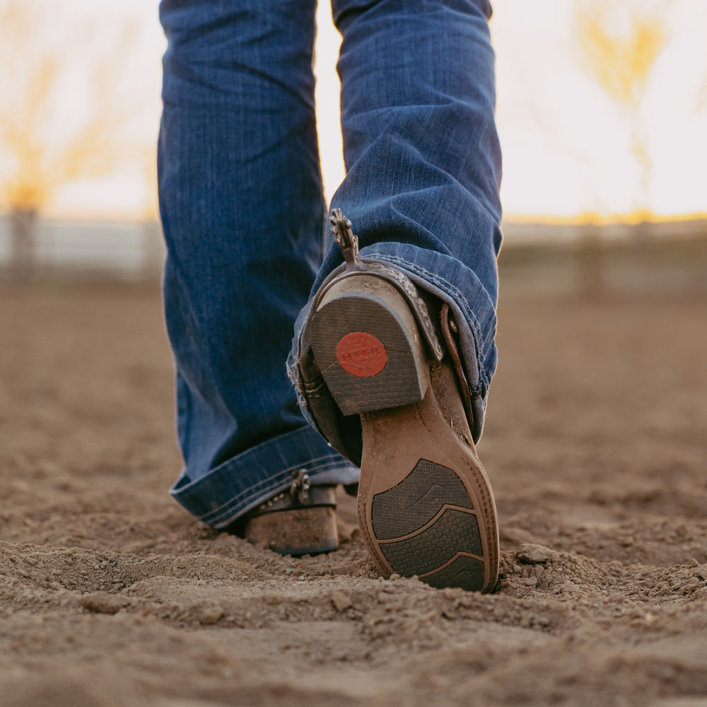 Rubber sole of cowboy boots in dirt