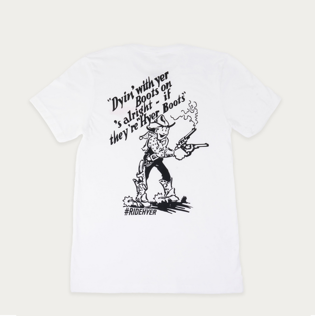 A white short-sleeve t-shirt with a black graphic print on the front. The graphic features a cowboy character, accompanied by the text 'Dyin' with yer Boots on's alright - if they're Hyer Boots' and the hashtag '#RIDEHYER'.