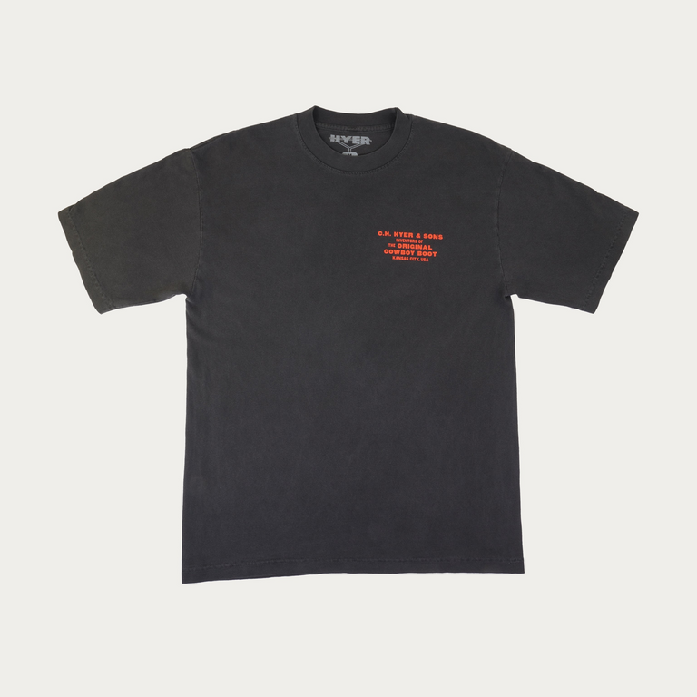 A faded black short-sleeve t-shirt with orange text printed on the left chest, displayed flat against a light gray background.