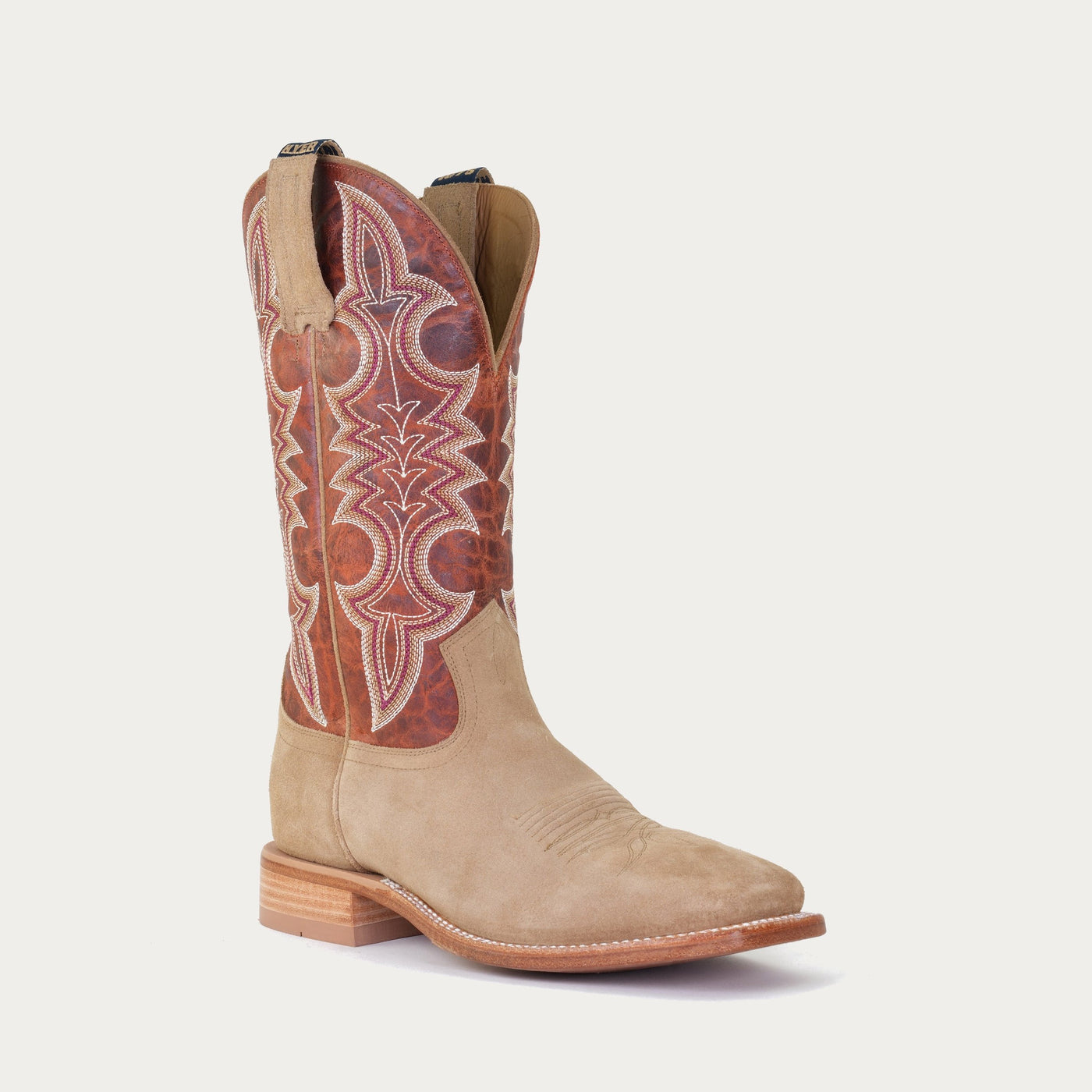 A beige and brown colored boot with intricate stitching on the shaft, featuring a low heel and a square toe.