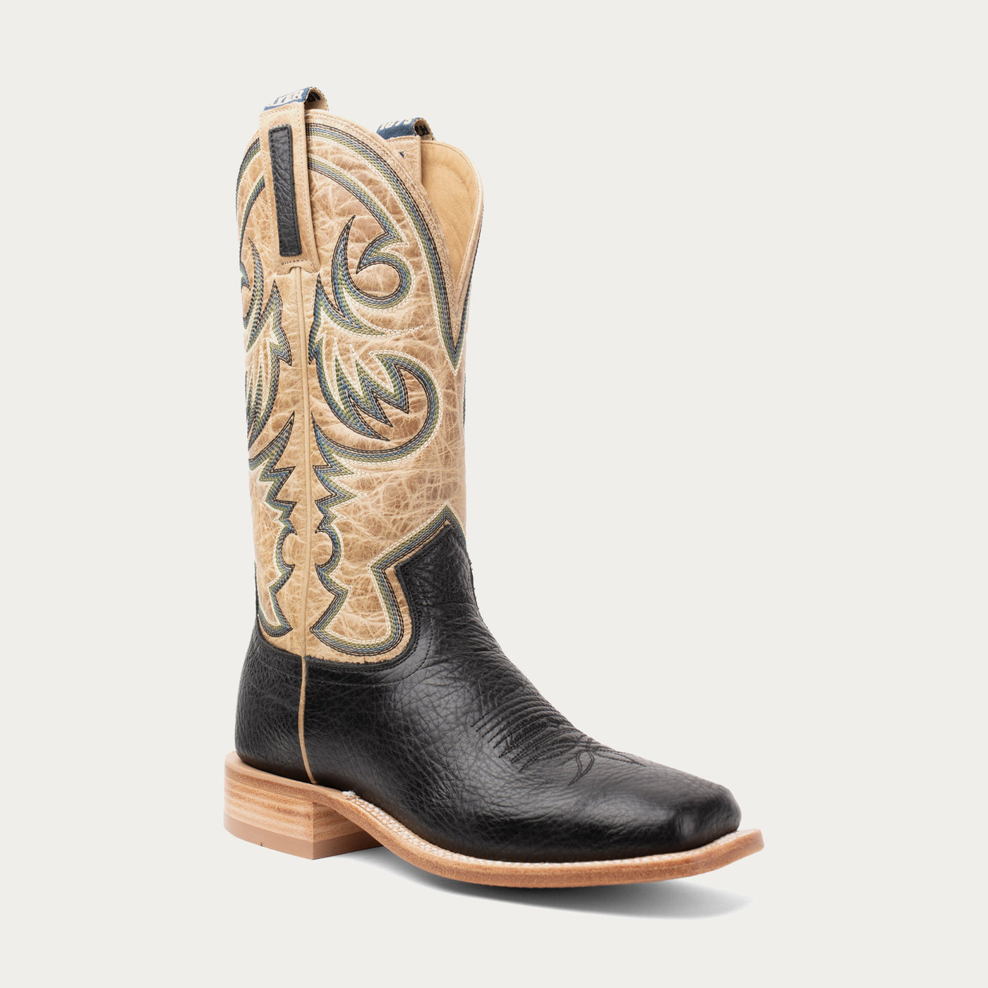 Black and tan cowboy boot on a white background