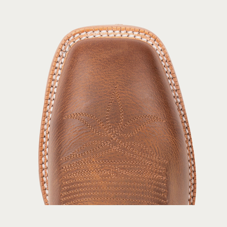 Close-up of a brown leather shoe with intricate stitching on a light gray background