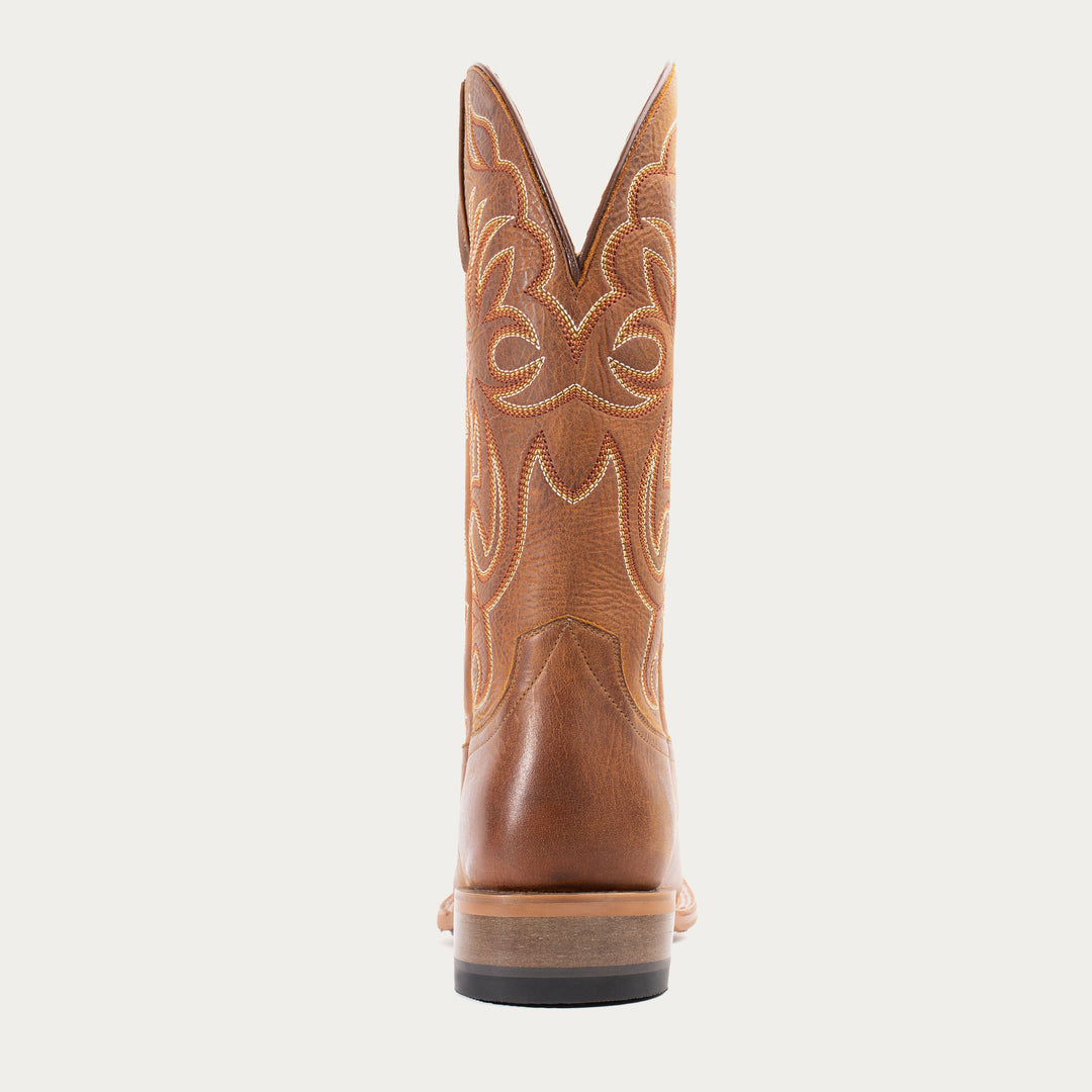 Brown cowboy boot with intricate design on a white background