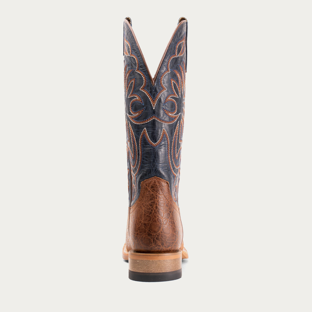 Brown cowboy boot with intricate stitching on a white background