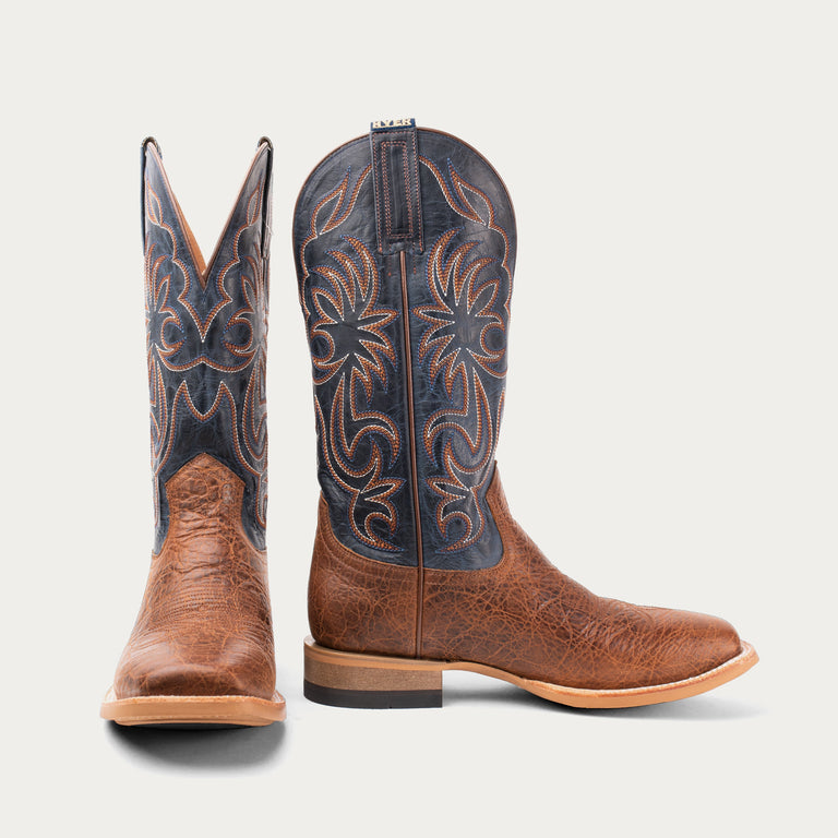 Pair of brown cowboy boots with intricate designs on a white background