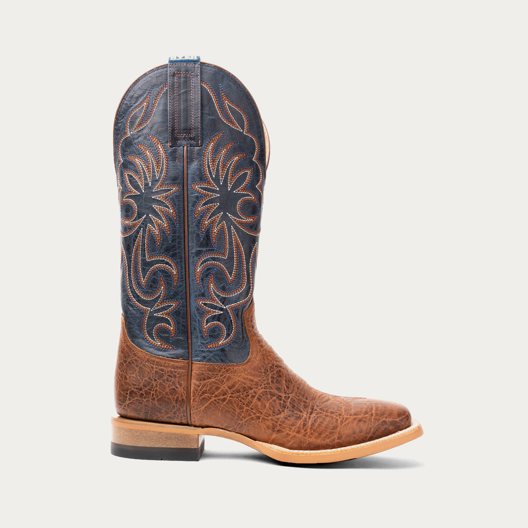 Brown cowboy boot with intricate blue and brown design on a white background