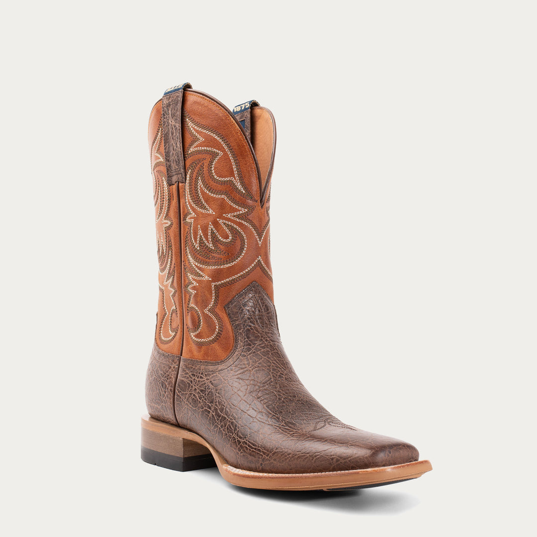 Brown cowboy boot with intricate white stitching on a light gray background