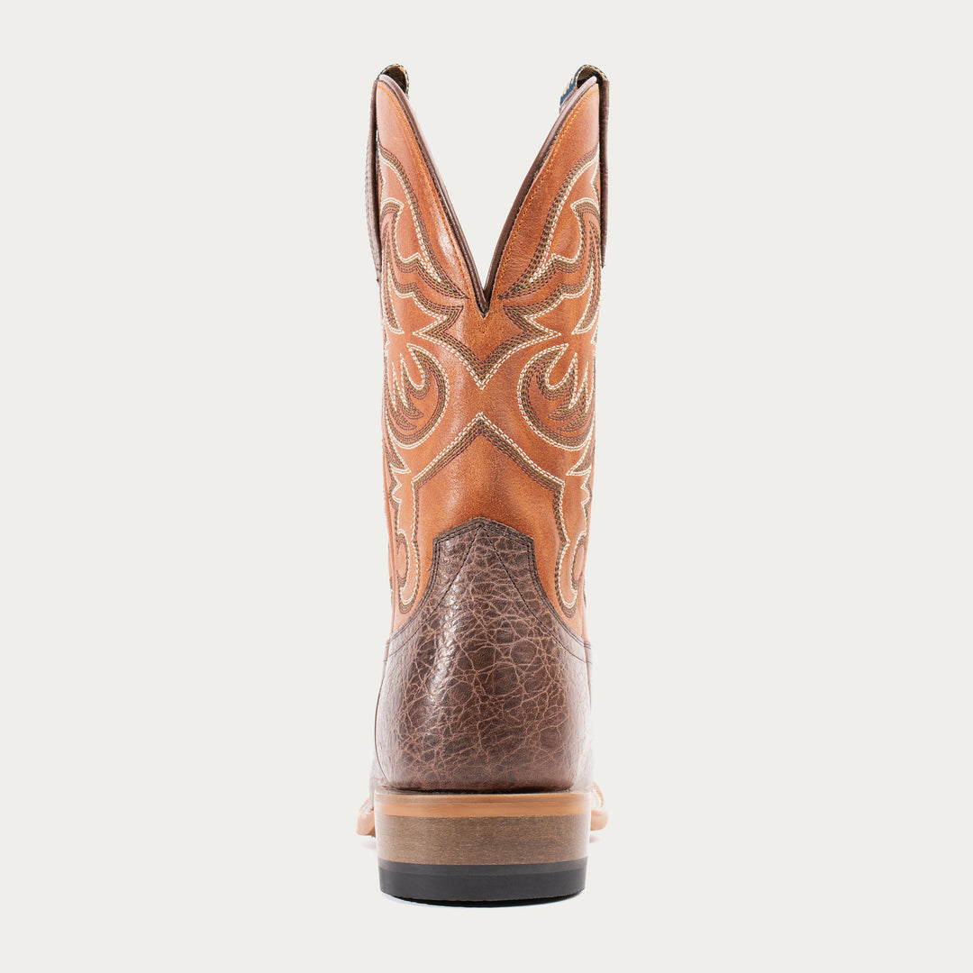 Brown cowboy boot with intricate design on a white background