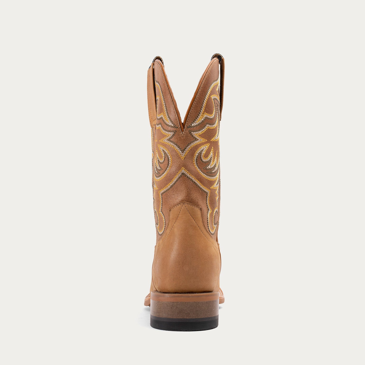 Brown cowboy boot with decorative stitching on a white background
