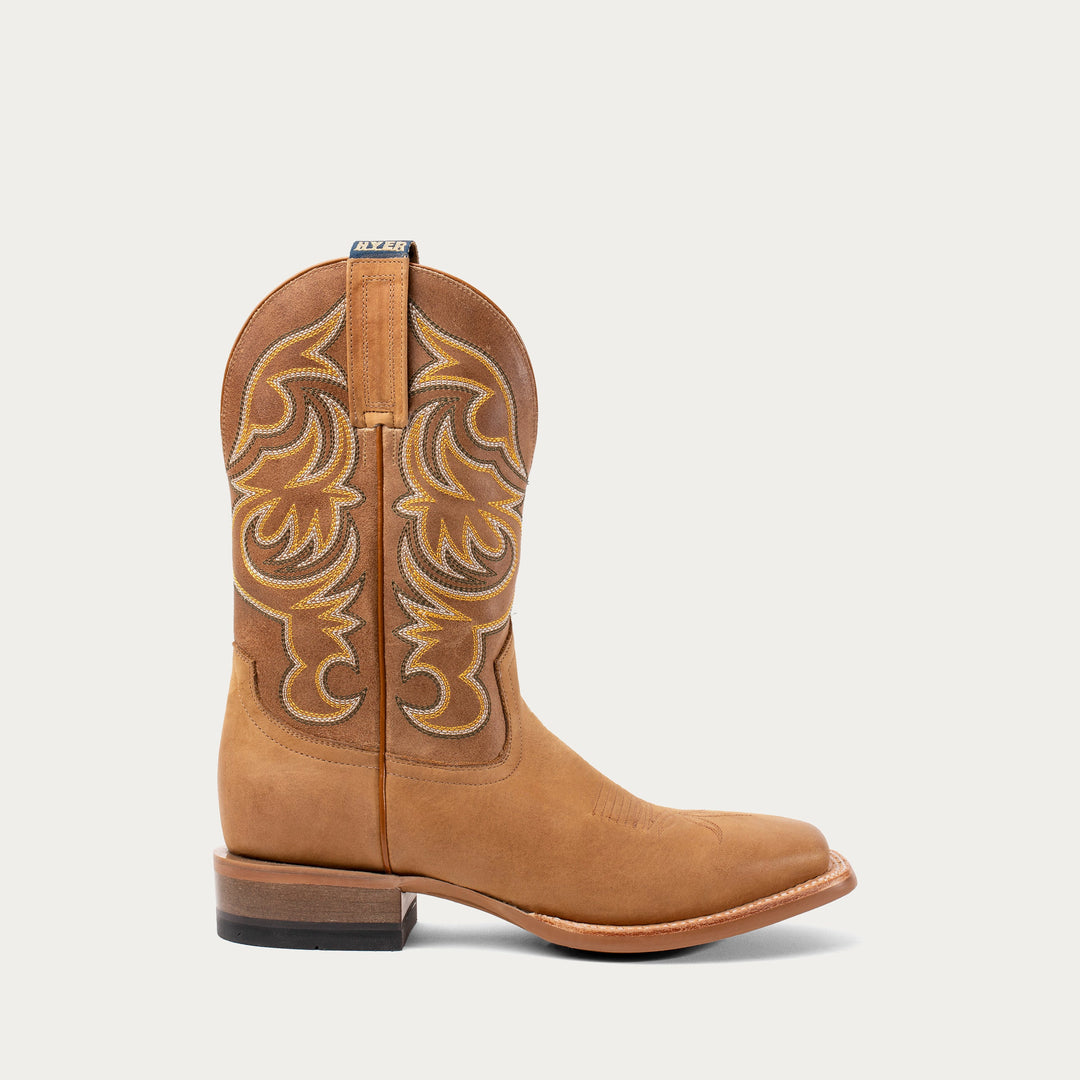 Tan cowboy boot with intricate stitching on a white background