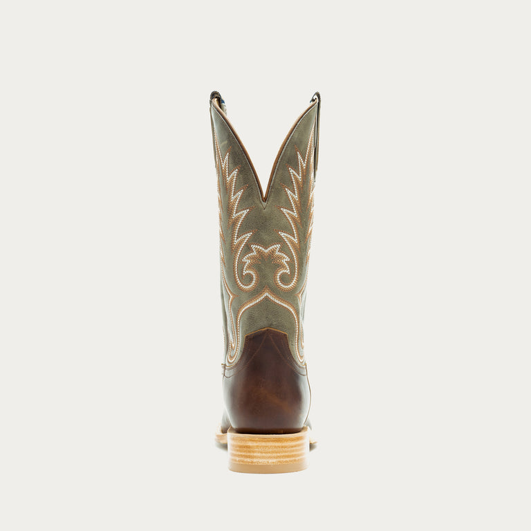 Green and brown cowboy boot with intricate design on a light gray background