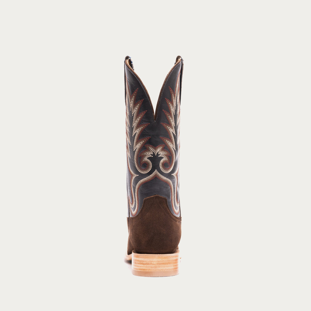 Brown and slate gray cowboy boot with intricate design on a light gray background