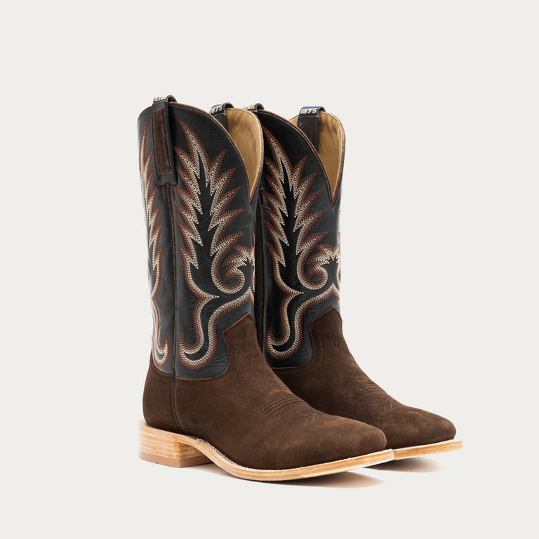 Pair of brown and slate gray cowboy boots with intricate designs on a light gray background