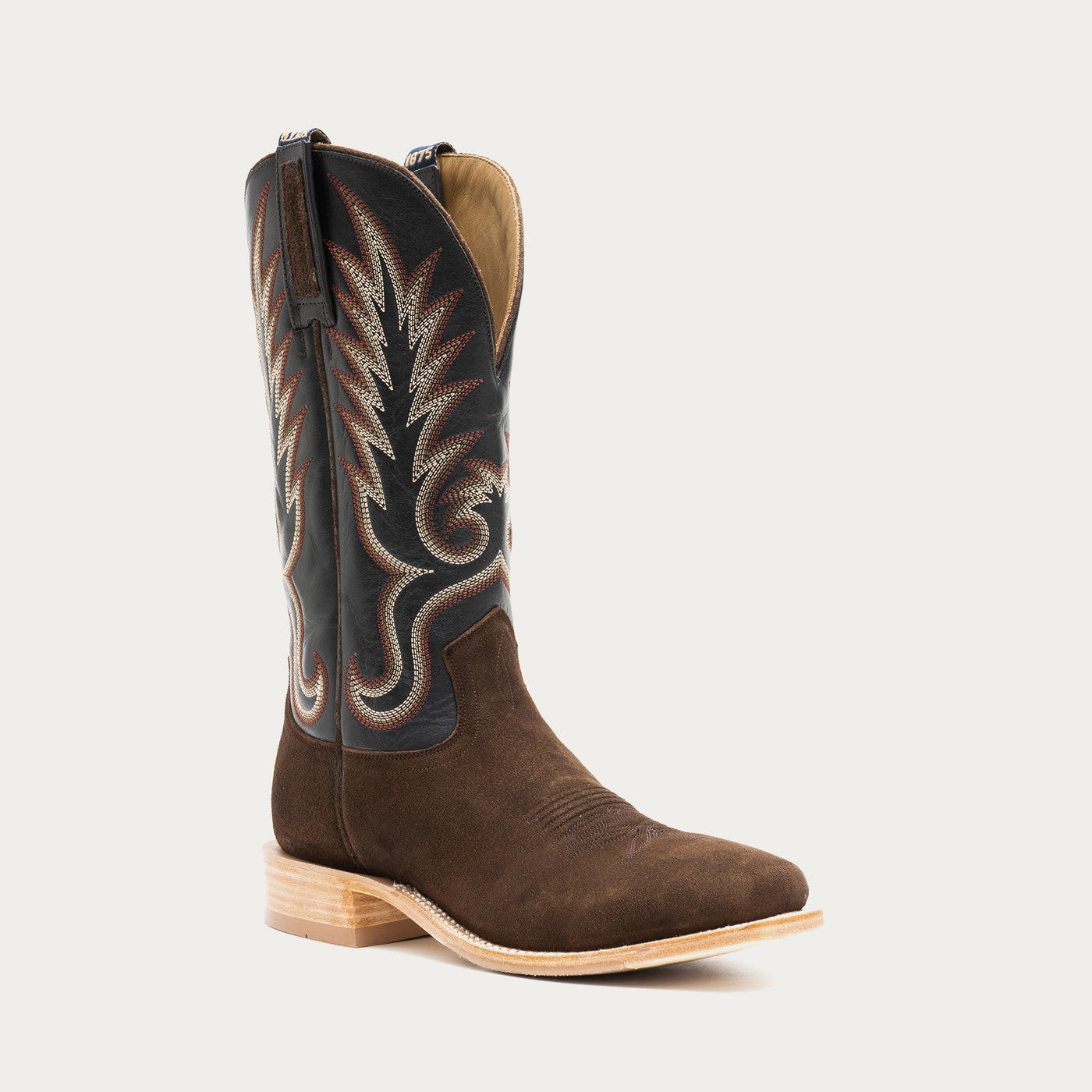 Brown and slate gray cowboy boot with black and tan embroidery on a light gray background