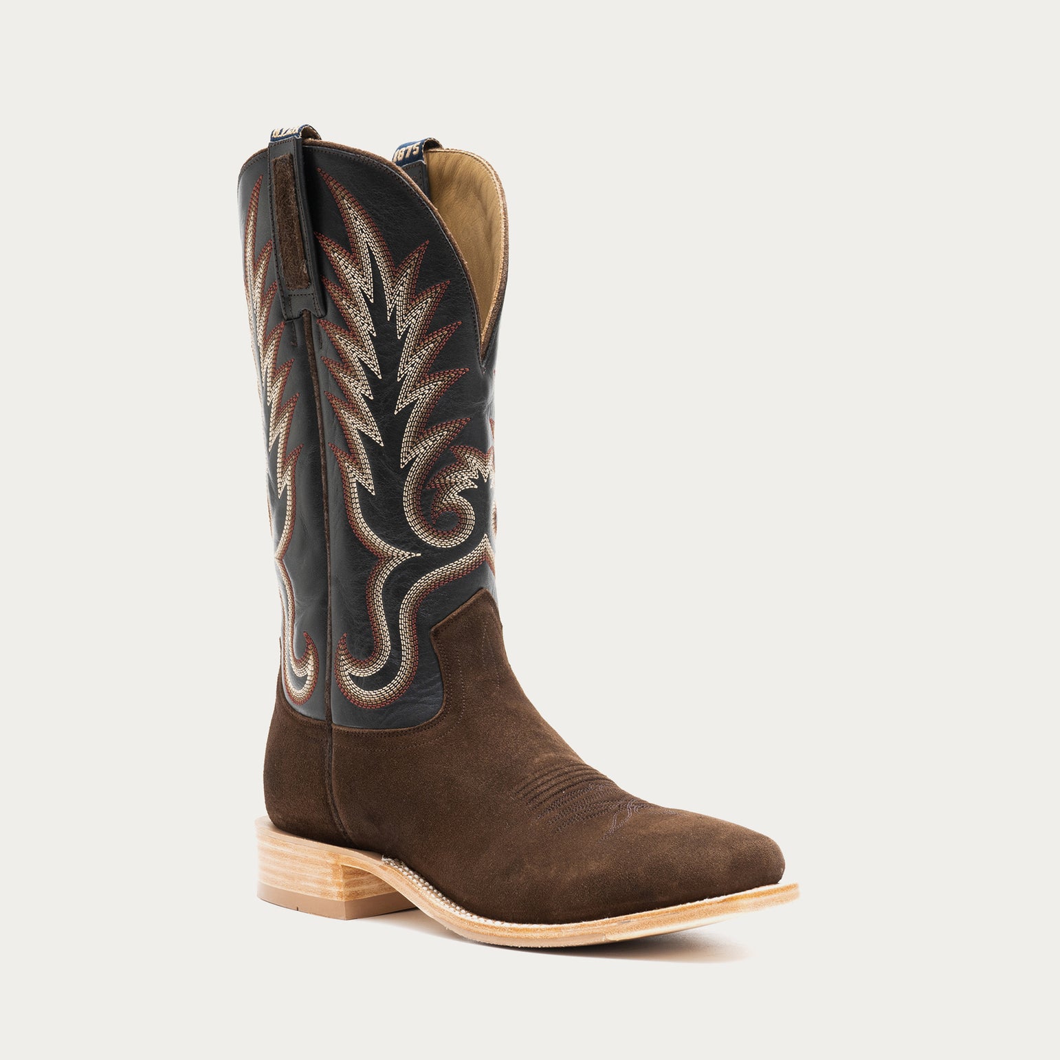 Brown and slate gray cowboy boot with black and tan embroidery on a light gray background