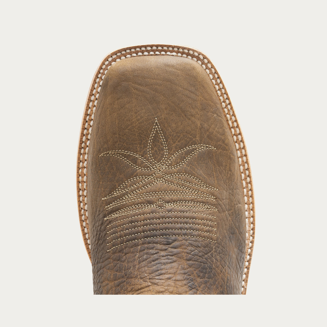 Close-up of a brown leather boot sole with intricate stitching on a light gray background