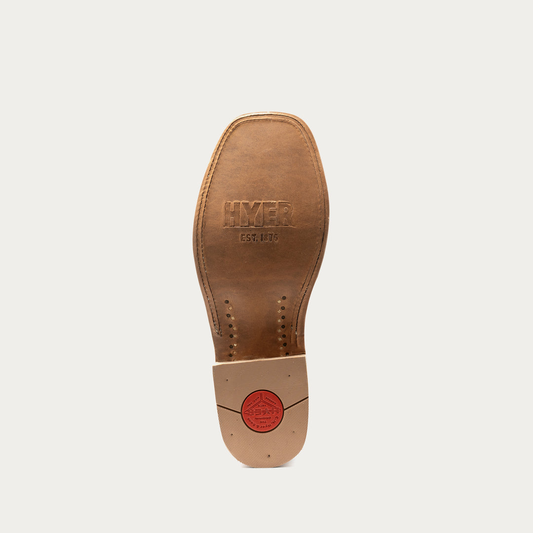 The outsole of a brown leather shoe, showing the embossed brand name 'HYER EST. 1875' and a red circular logo stamp on the heel, set against a light gray background.
