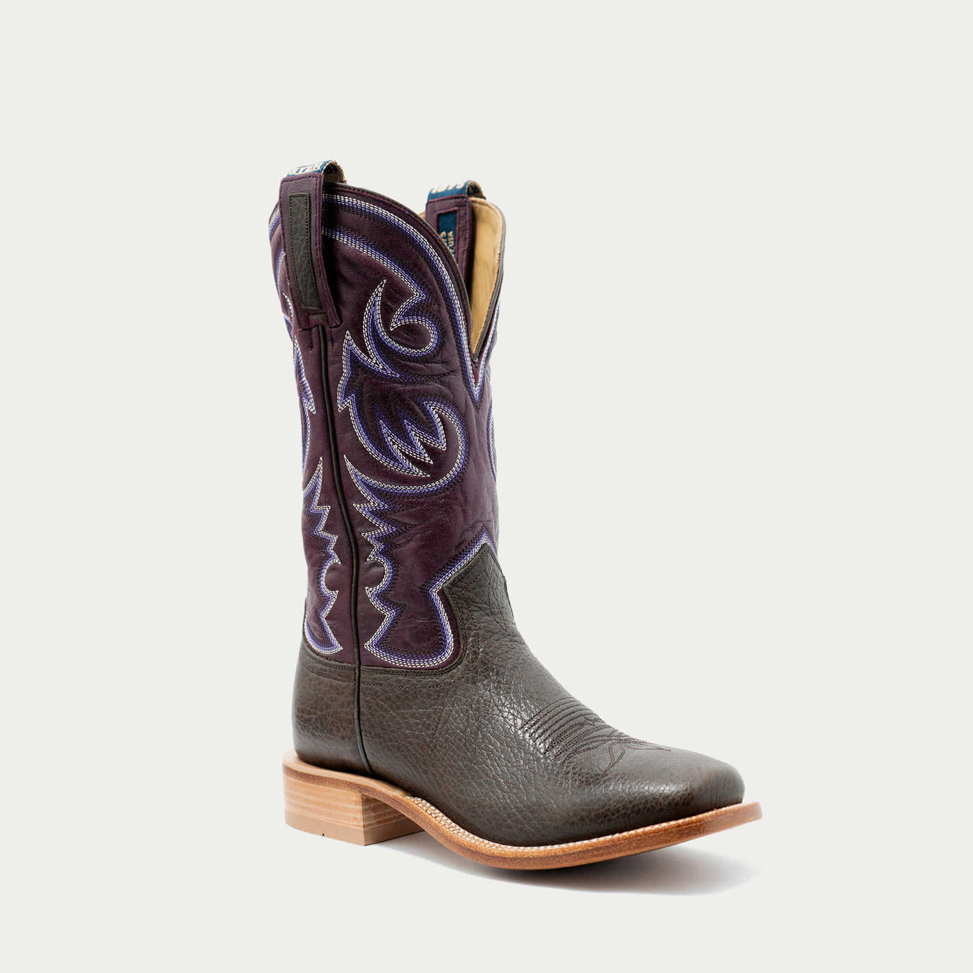 A single mid-calf western cowboy boot with a dark brown leather foot and a dark purple shaft featuring light purple embroidered stitching, shown against a light gray background.