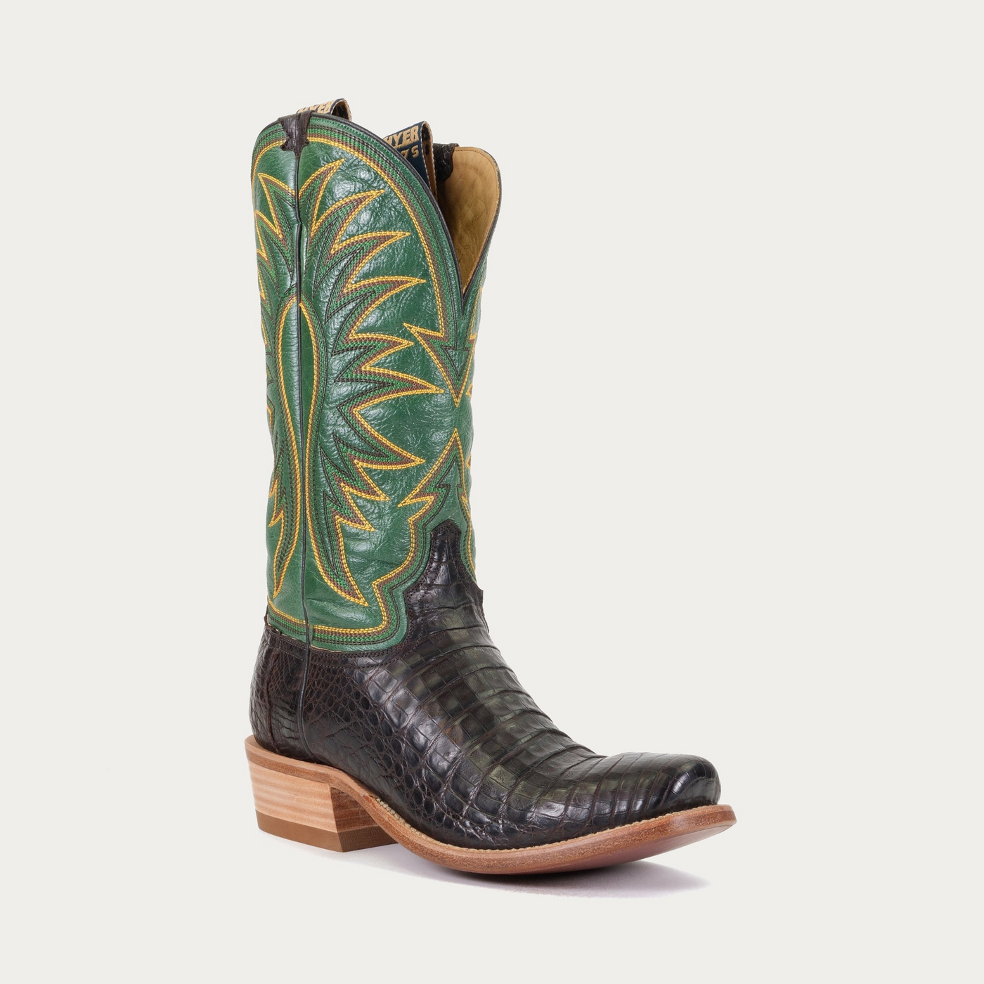 A black and green cowboy boot with a cutter toe and low heel, set against a white background.