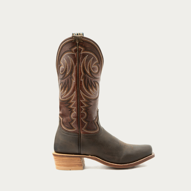 Brown cowboy boot with intricate embossing on a white background