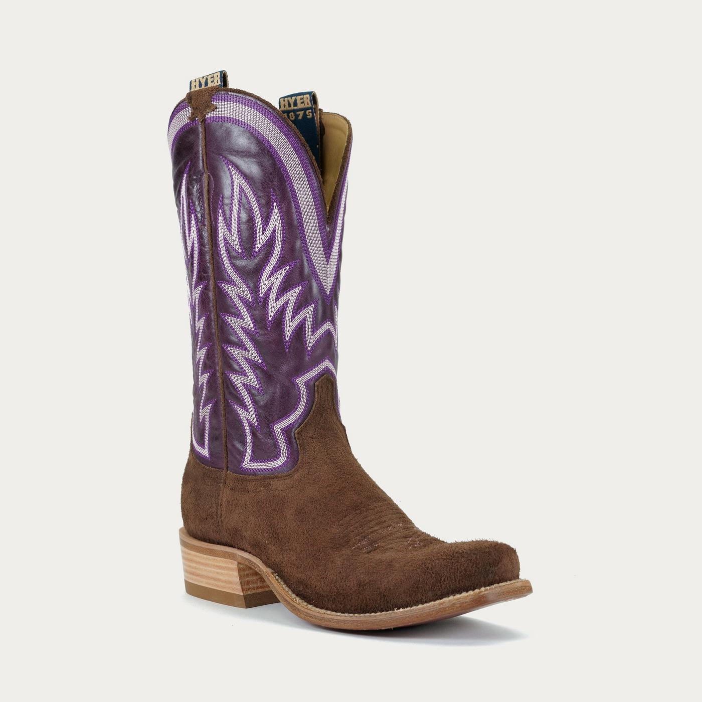 A brown and purple cowboy boot with a full grain roughout vamp, cutter toe, and low leather stacked heel.