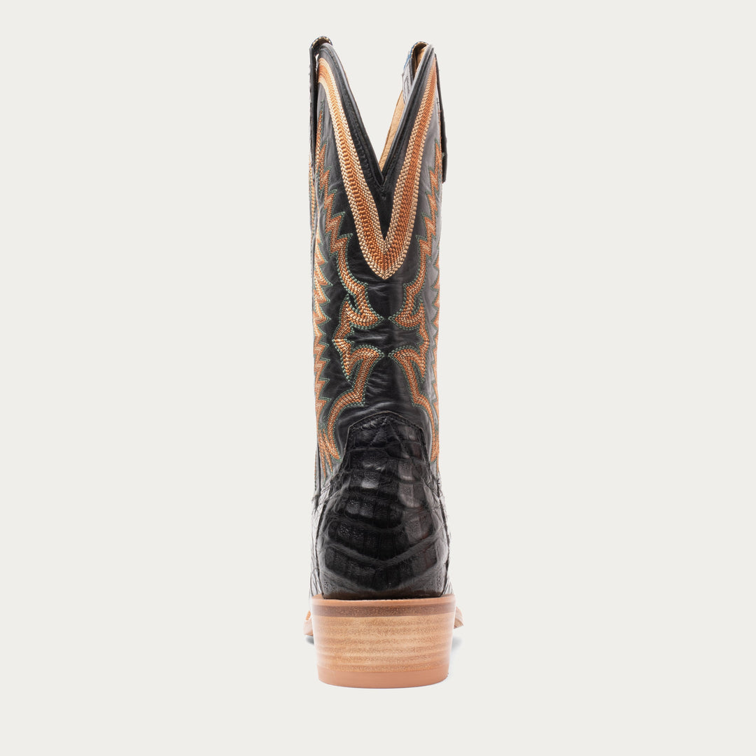 Black cowboy boot with brown accents on a white background