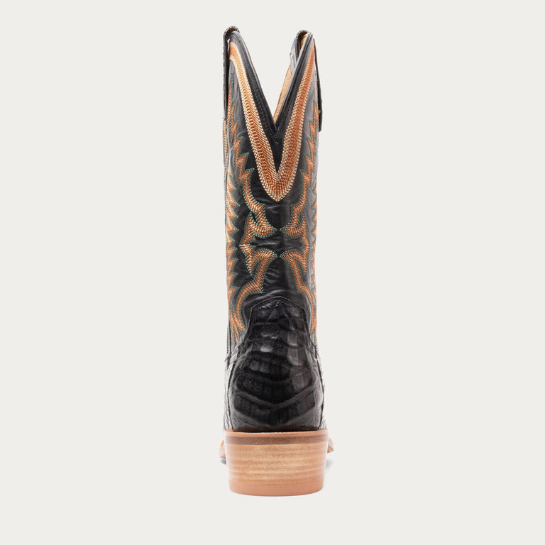 Black cowboy boot with brown accents on a white background