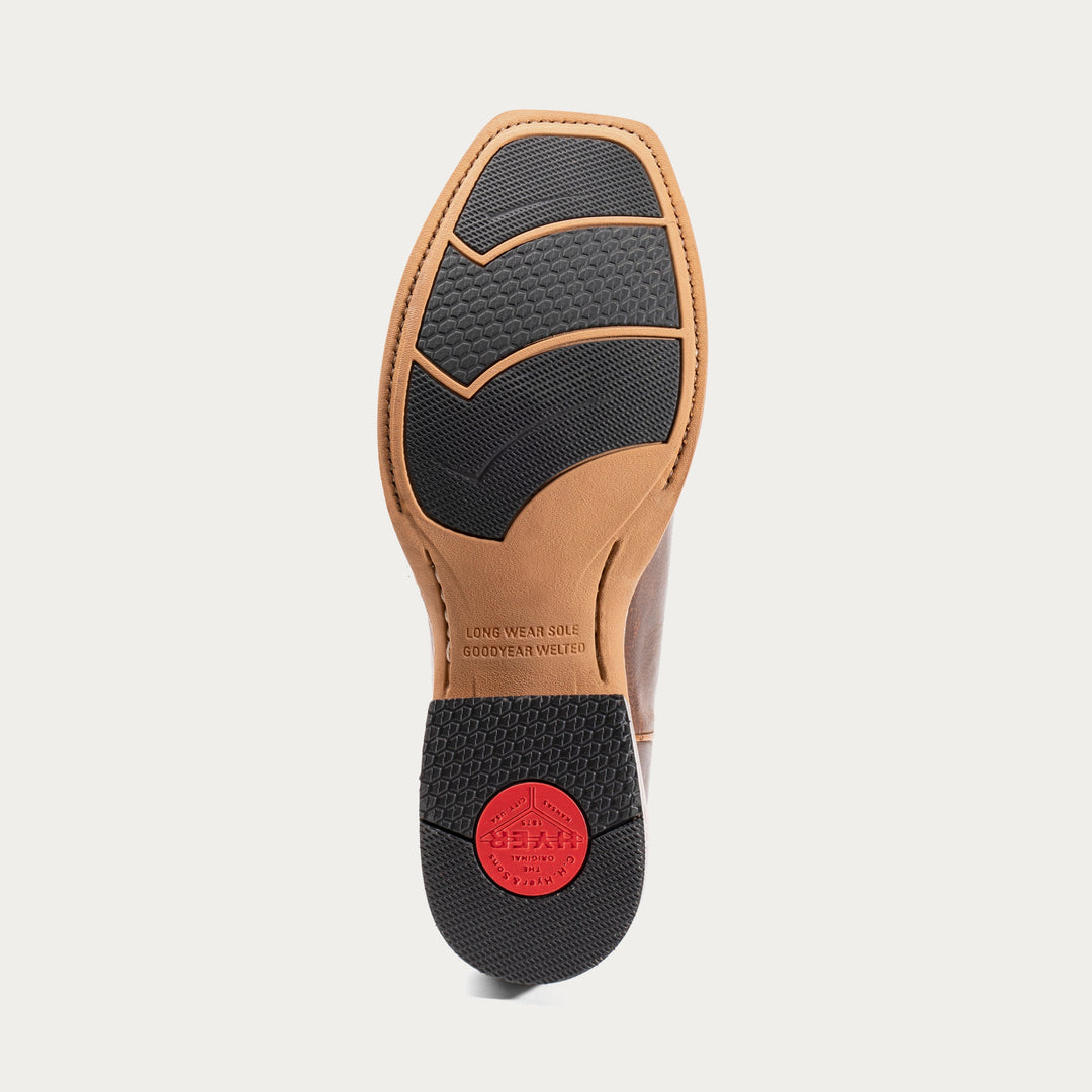 Shoe sole with black tread pattern and red label on a light gray background