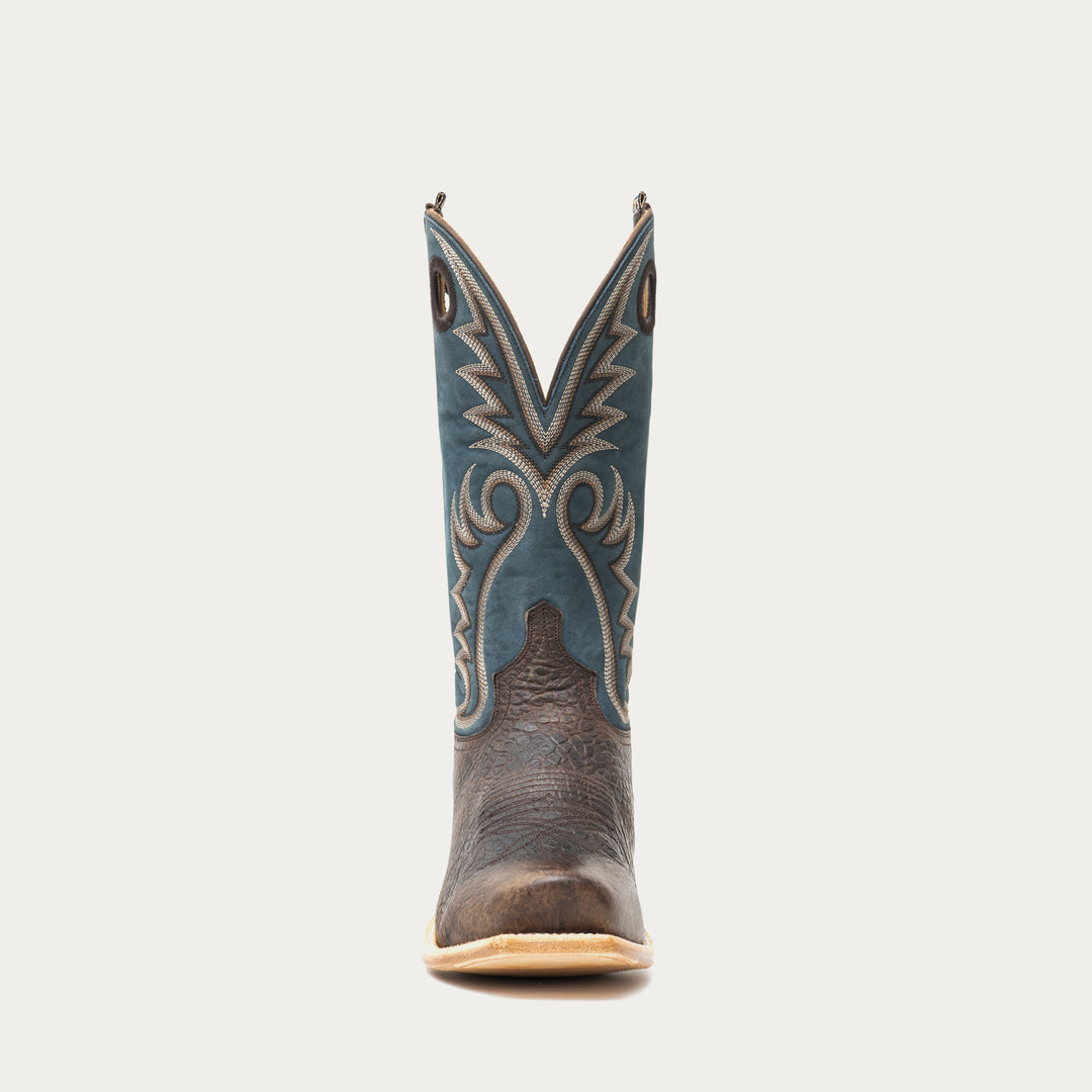 Brown and blue cowboy boot with blue decorative pattern on a gray background