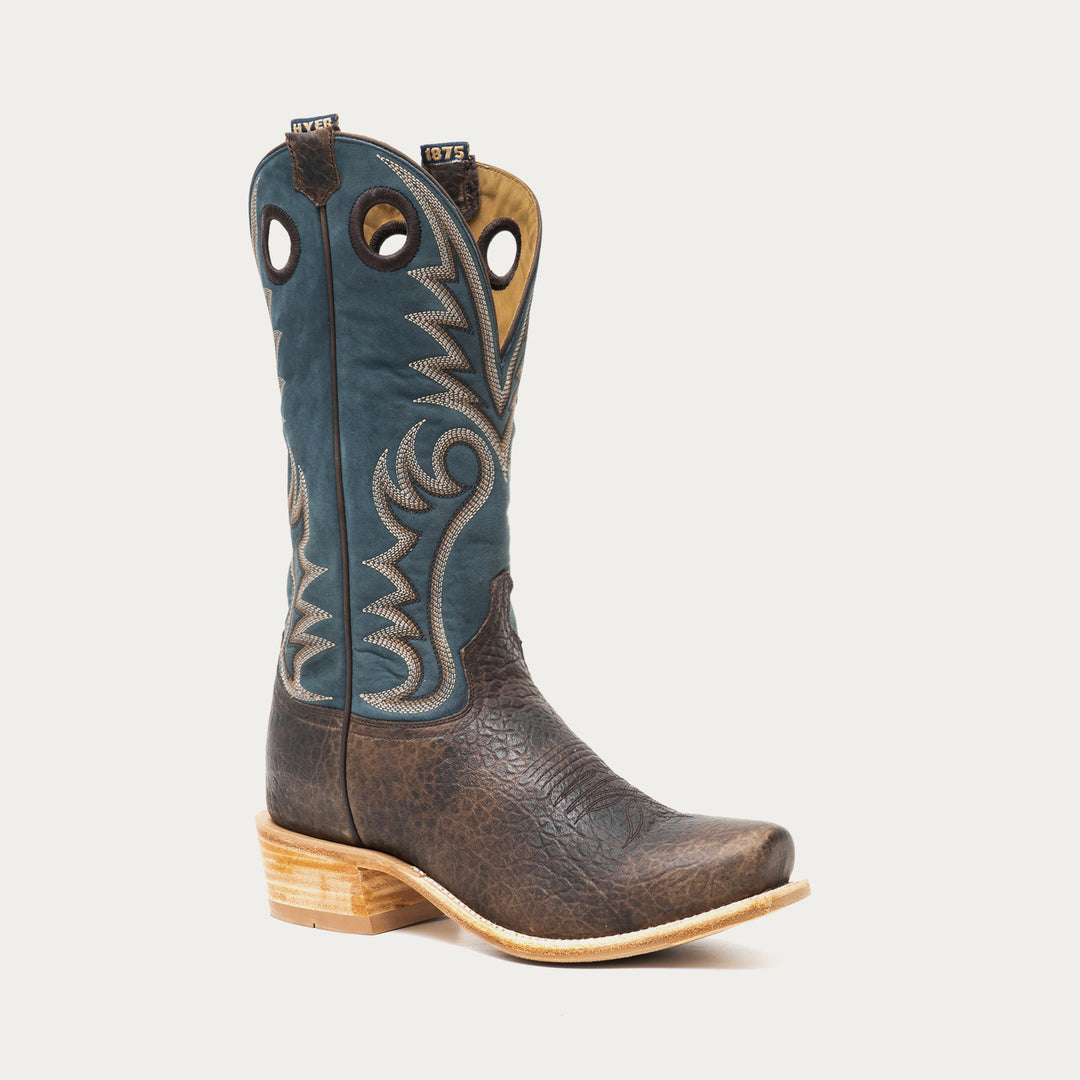 Brown and blue cowboy boot with intricate stitching on a gray background