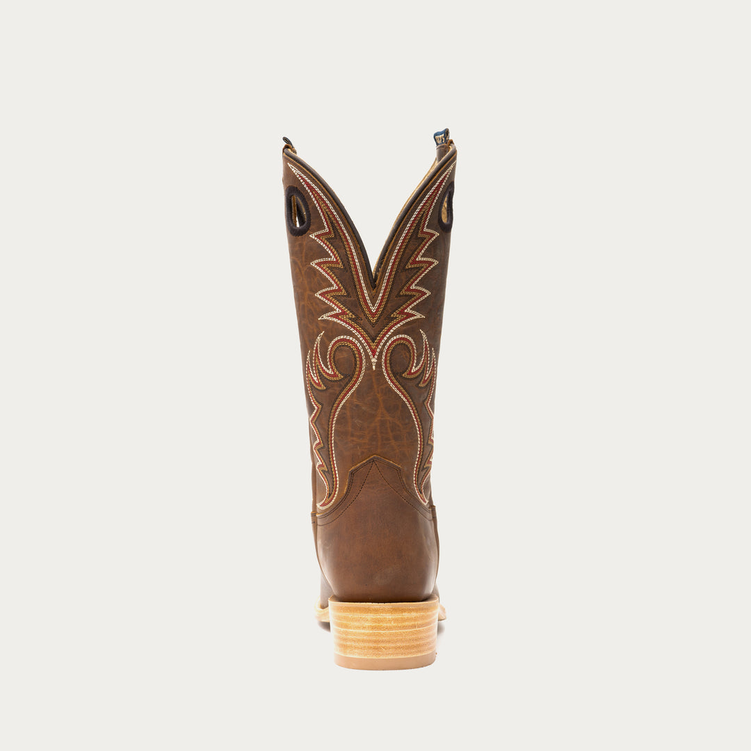 Brown cowboy boot with intricate stitching on a light gray background