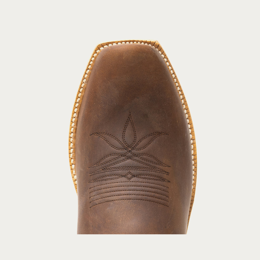 Brown leather boot with intricate stitching on a light gray background