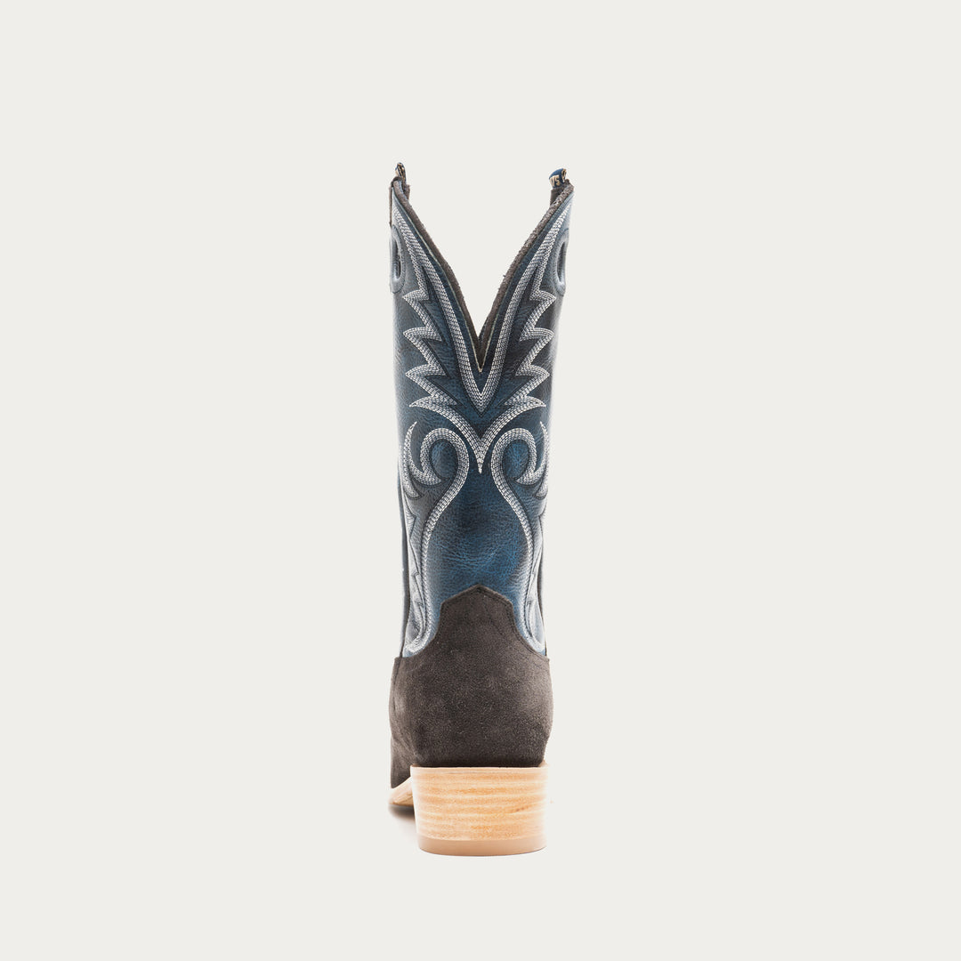 Blue and charcoal gray cowboy boot with decorative pattern on a light gray background