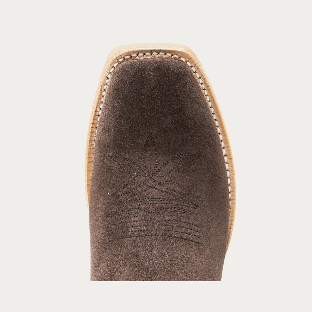 Brown cowboy boot toe with tonal brown stitching on a light gray background