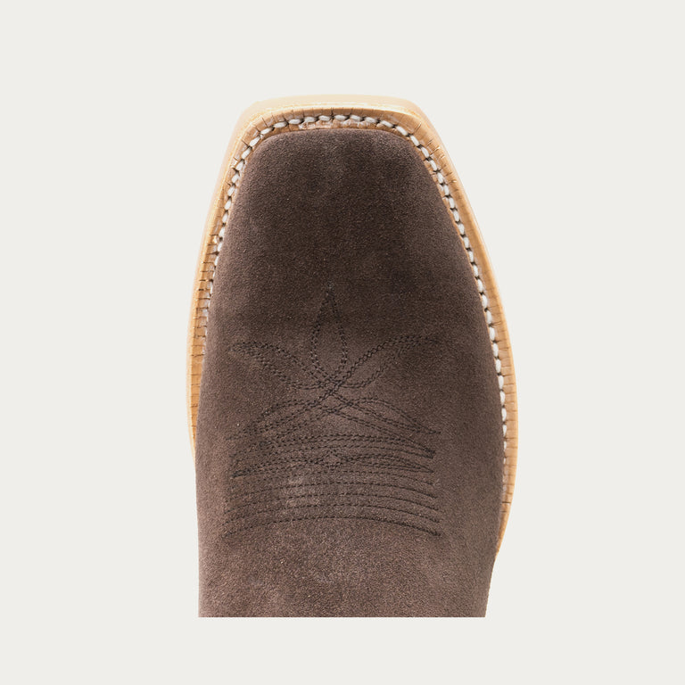 Brown cowboy boot toe with tonal brown stitching on a light gray background