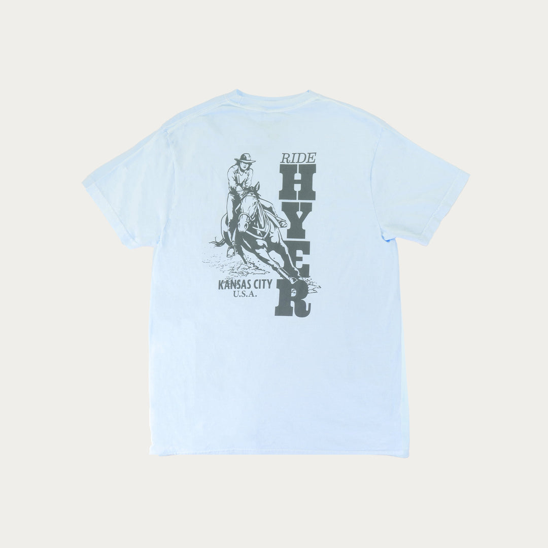 Light blue t-shirt with a graphic of a person riding a horse and text on the back, on a light gray background.