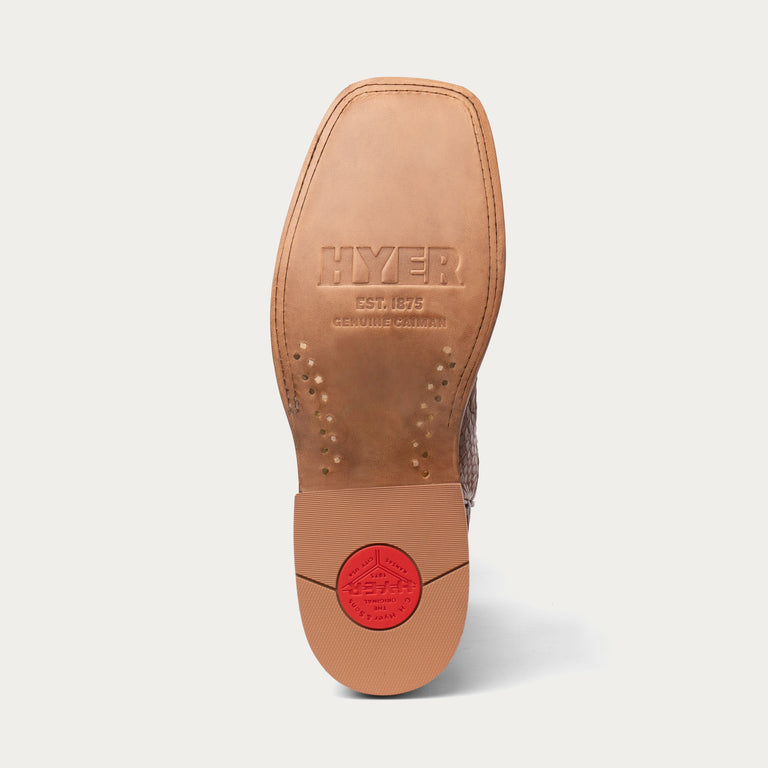 Close-up of a brown leather shoe sole with 'HYER' branding on a white background