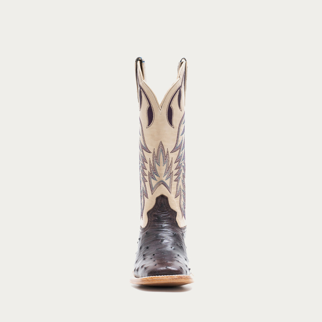Off white and dark purple cowboy boot with decorative pattern on a light gray background