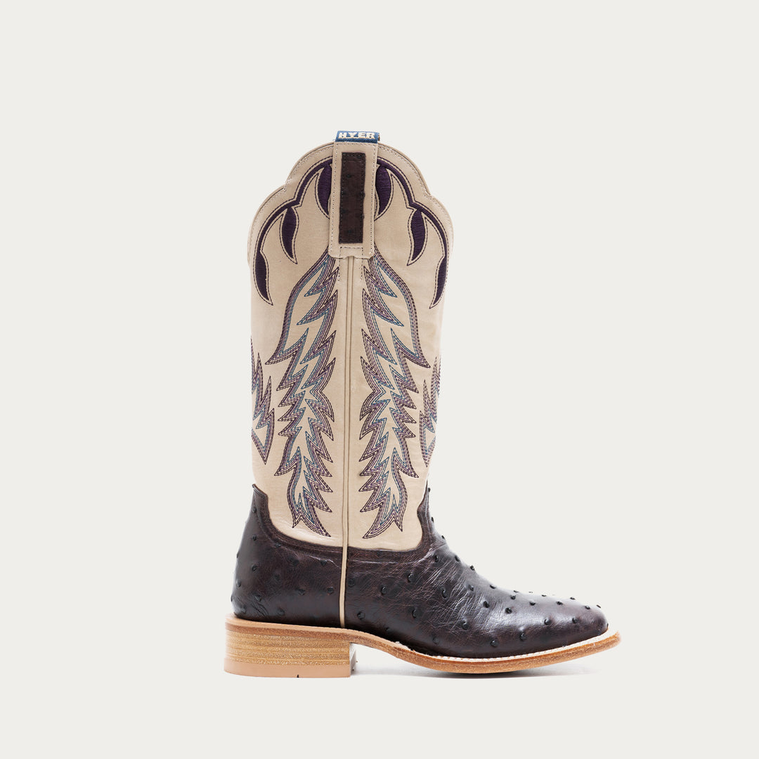 Off white and dark purple cowboy boot with decorative pattern on a light gray background