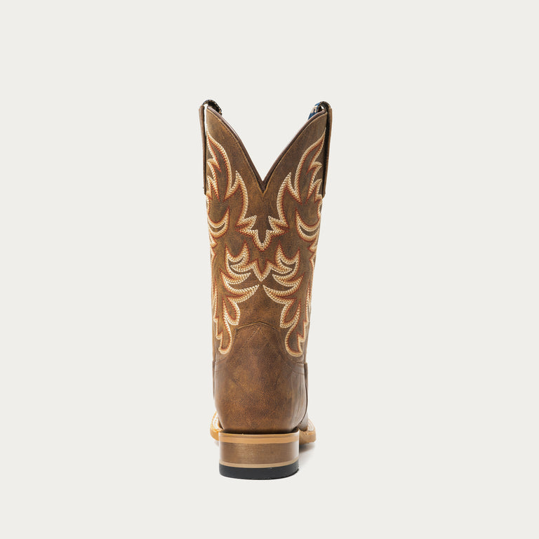 Brown cowboy boot with intricate designs on a light gray background