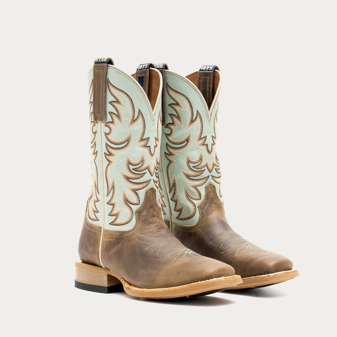 Pair of brown and light blue cowboy boot with tan and brown embroidery on a light gray background