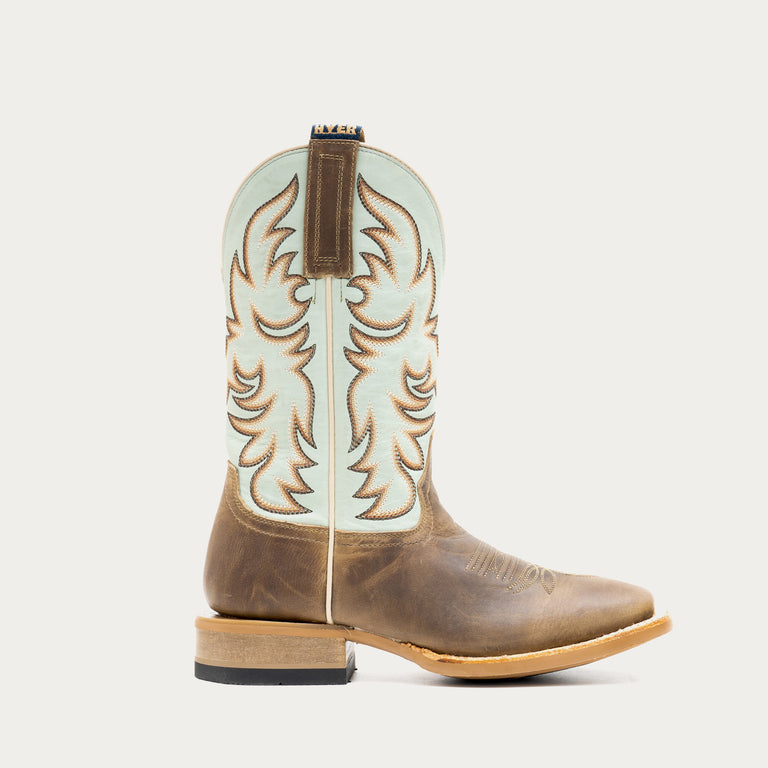 Brown and light blue cowboy boot with tan and brown embroidery on a light gray background