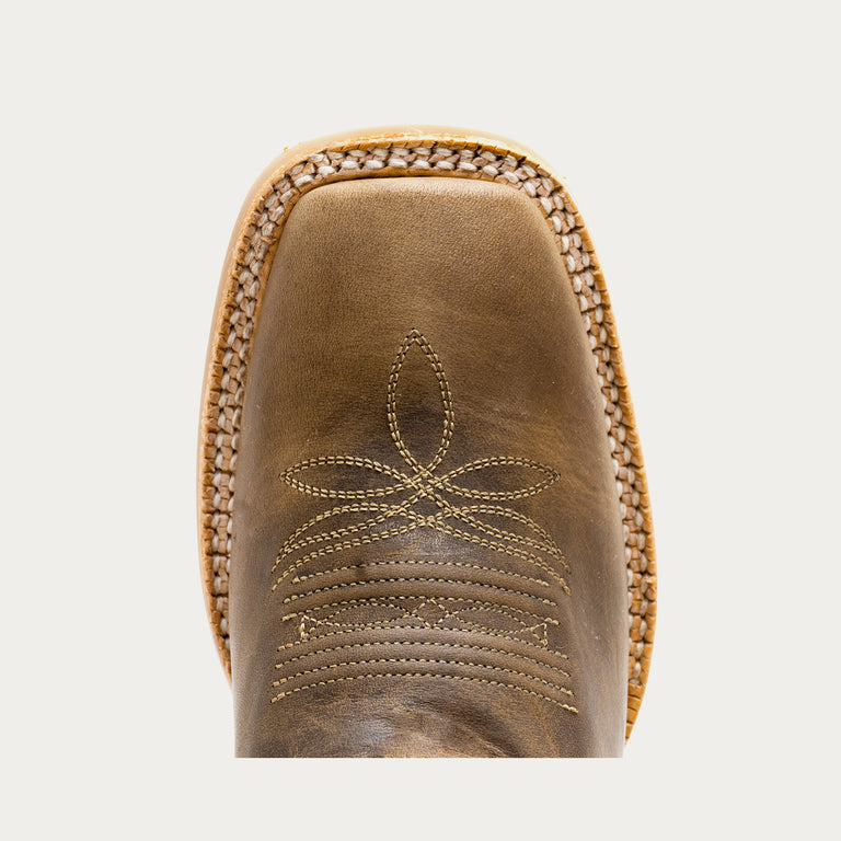 Close-up of a brown leather boot with intricate stitching on a light gray background