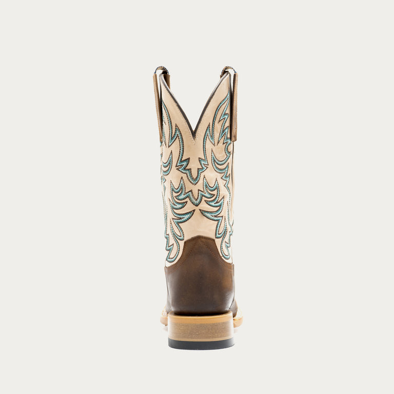 Brown and off white cowboy boot with intricate brown and blue embroidery on a light gray background