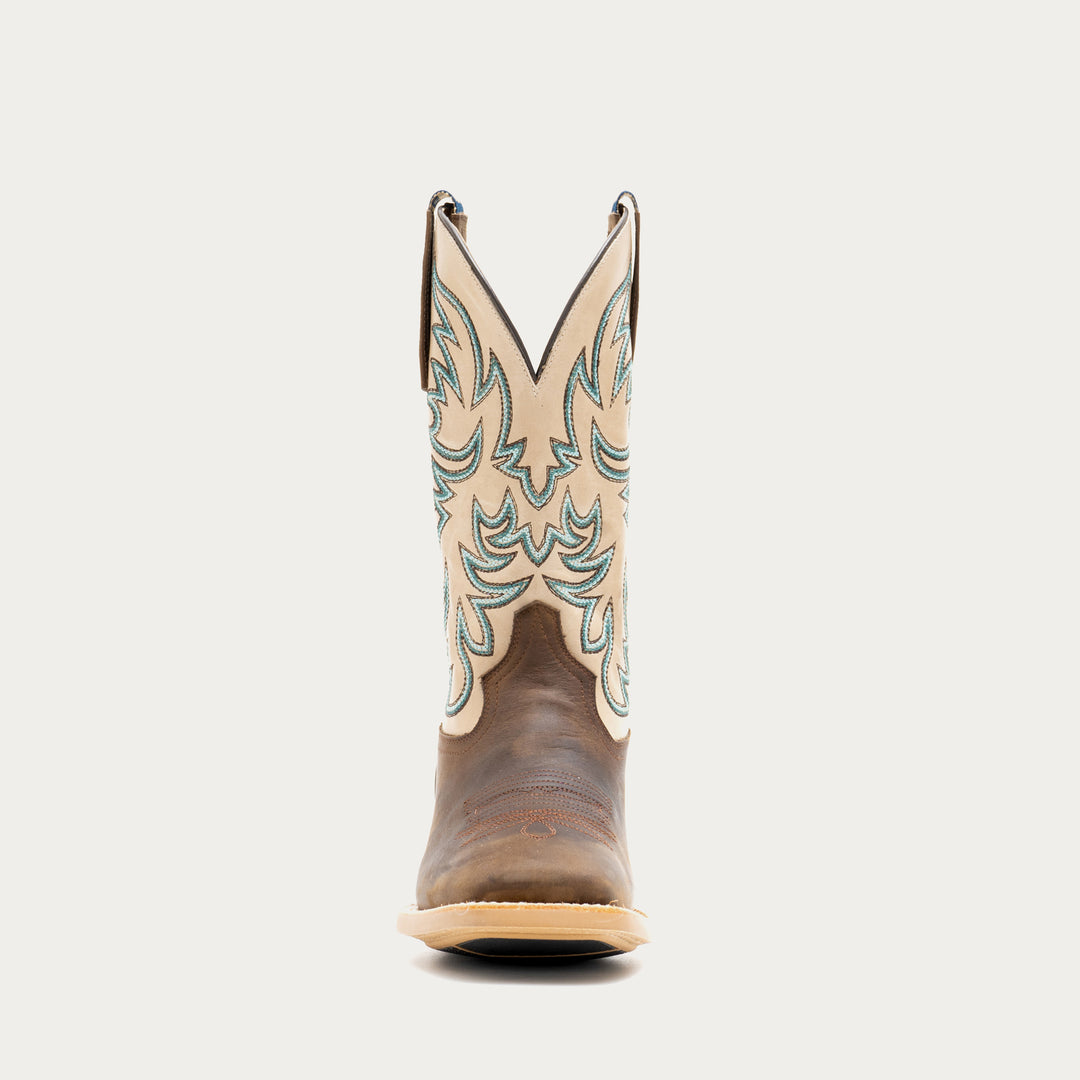 Brown and off white cowboy boot with intricate brown and blue embroidery on a light gray background