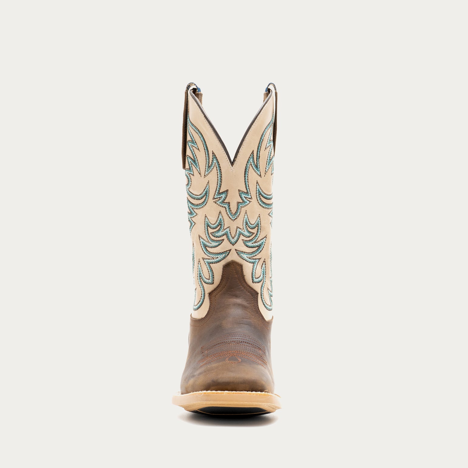Brown and off white cowboy boot with intricate brown and blue embroidery on a light gray background