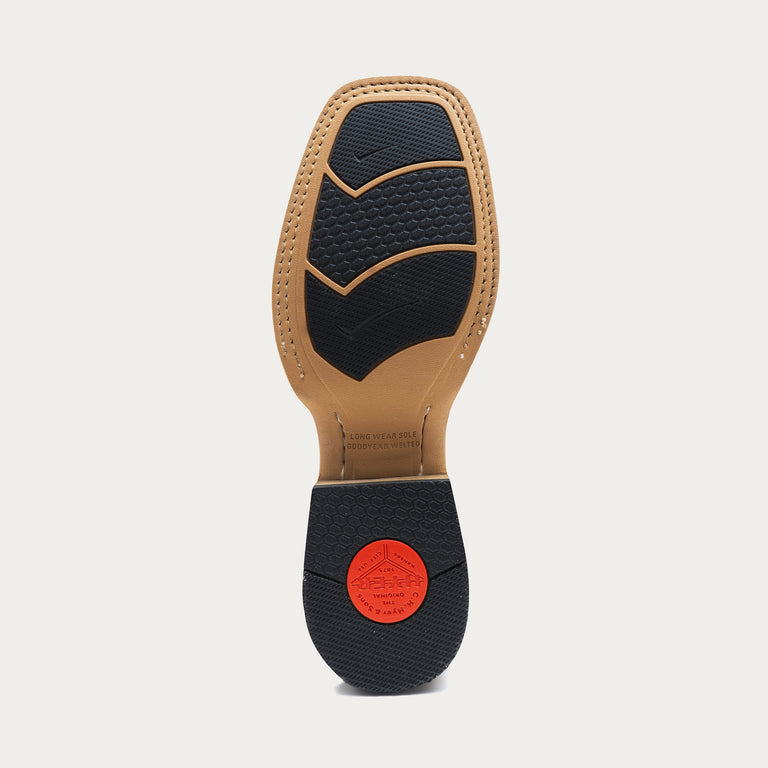 Close-up of a tan shoe sole with black rubber inset and a red heel cap on a light gray background