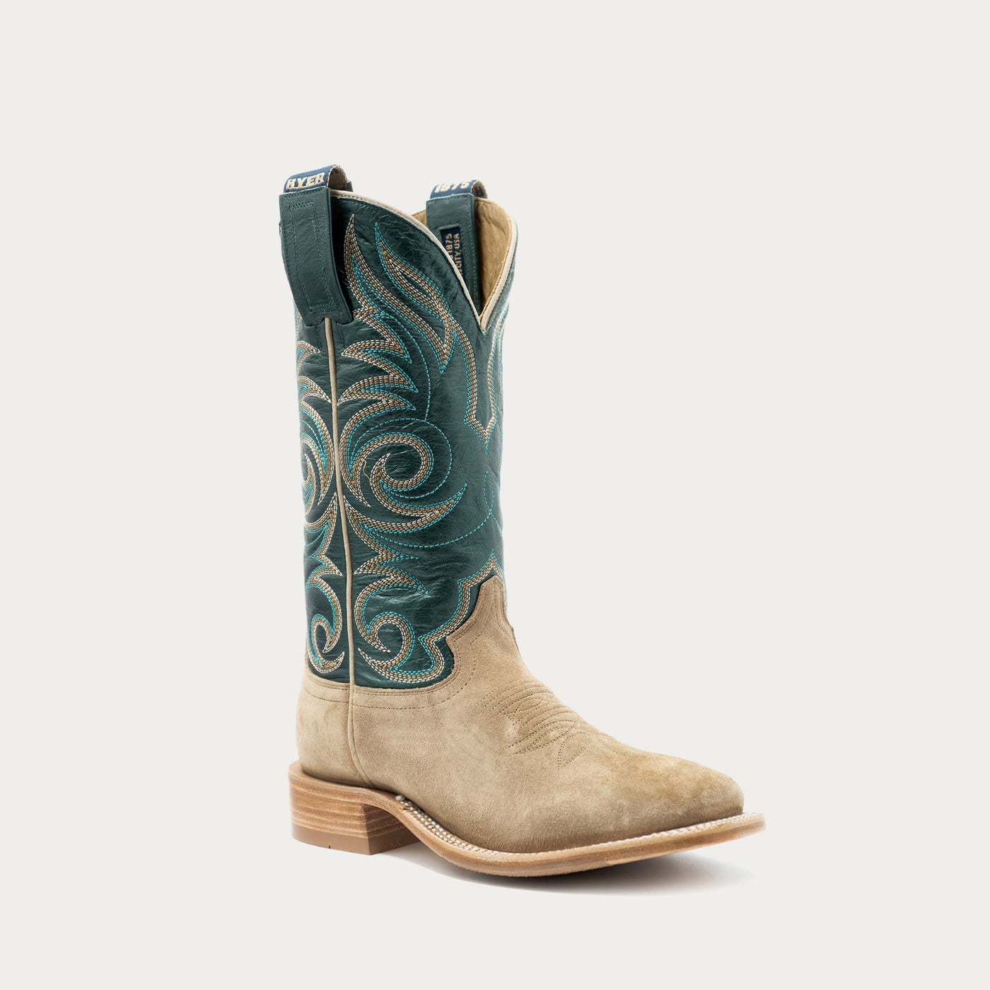 A single western cowboy boot shown in profile against a light gray background. The boot has a tan suede lower body and a dark teal shaft with ornate embroidered swirl patterns in teal and light tan.